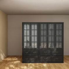 an empty room with black cabinets and wooden floors