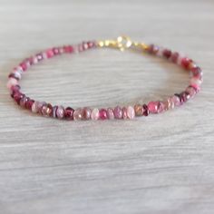 This is a skinny  pink shaded  bracelet with tiny Rhodolite Garnet, Pink Garnet and pink Tourmaline genune gemstones  The gemstone  are strung on the highest quality metal strand  beading wire,which is extremely strong and flexible.     The gemstones  measure 2 -3 m in diameter.  The bracelet closes with a   gold filled spring ring clasp The length of the bracelet is 18 cm   inch  7.08 I can always add an extension chain at no extra charge Thanks for stopping by. See my other handcrafted preciou Adjustable Pink Gemstone Beaded Bracelets, Red Gemstone Dainty Bracelets, Pink Ruby Bracelets With Gemstone, Adjustable Pink Gemstone Bracelet, Garnet And Rose Quartz Bracelet, Pink Garnet, Tourmaline Bracelet, Garnet Bracelet, Red Gemstones