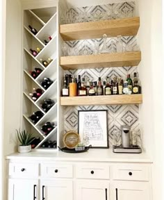 a kitchen with white cabinets and shelves filled with bottles