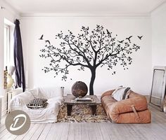 a living room with a tree painted on the wall