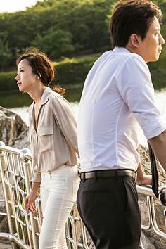 a man and woman walking across a bridge