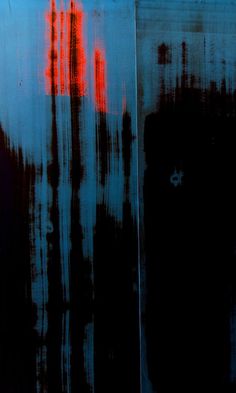 an abstract painting with red and blue colors on the side of a metal structure that looks like it has been painted