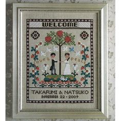 a cross stitch picture with a couple holding hands in front of a tree and flowers