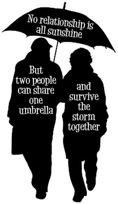 two people walking under an umbrella with words on it