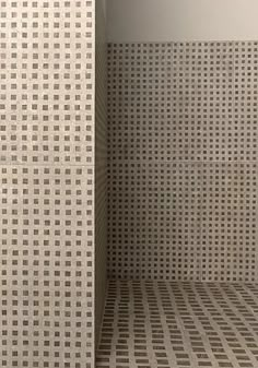 the corner of a room with white and brown wall coverings on it's walls