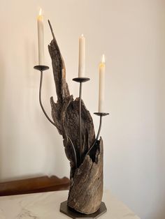 a candle holder made out of driftwood with three candles