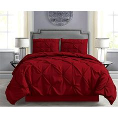 a bed with red comforter and pillows in a room