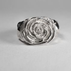 **Please note that we dispatch on Tuesdays unless special delivery express option is paid for** Sterling silver Camellia ring. Original design carved in wax then lost wax cast into solid sterling silver.  Piece weighs approximately 17g.  Shown in a size N, and adjustable to ring sizes I-S.  A significant size adjustment may alter the appearance slightly.  First class post included, with a supplement for special delivery. Sterling Silver Carved Promise Ring, Unique Hand Cast Sterling Silver Signet Ring, Silver Carved Signet Ring Gift, Hand Cast Sterling Silver Engraved Ring For Wedding, Silver Hand Cast Engraved Ring For Promise, Carved Sterling Silver Rings For Anniversary, Carved Sterling Silver Signet Ring Gift, Silver Carved Signet Ring For Wedding, Hand Cast Sterling Silver Engraved Ring