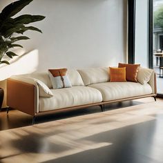 a living room filled with furniture next to a large glass window and a potted plant