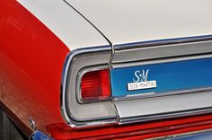 the rear end of an old red and white car with a sky captain sticker on it