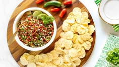 a wooden plate topped with chips and salsa