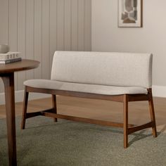 a wooden bench sitting on top of a carpeted floor next to a coffee table