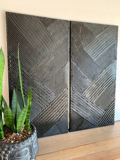 a potted plant sitting on top of a wooden table next to two black wall panels