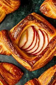 baked pastries with apple slices and cinnamon swirl on top, arranged in the shape of heart