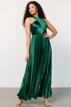 a woman in a green dress posing for the camera with her hands on her hips