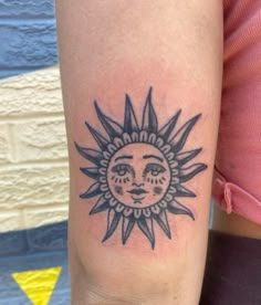 a woman with a sun tattoo on her arm