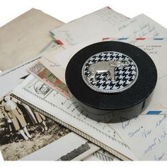 a black and white box sitting on top of an envelope filled with letters, postcards and other items