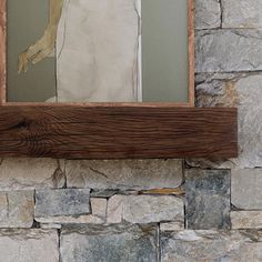 the reflection of a woman in a mirror on a stone wall behind a wooden frame