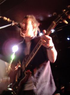 a man that is standing up with a guitar