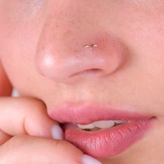 a close up of a woman's nose with a tiny nose piercing on it