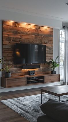 a living room with a couch, coffee table and large television on the entertainment center