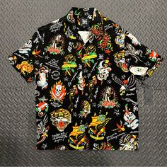 Stand Out From The Crowd With This Ed Hardy Button-Up Shirt. Featuring A Striking Graphic Print Of Skulls, Birds And Tattoos, This Shirt Is Perfect For Any Occasion - From Casual Hangouts To Workwear. The Collared Neckline And Short Sleeves With Button Closure Make It Ideal For Summer, While The Viscose Material Ensures It's Lightweight And Easy To Care For. Add Some Personality To Your Wardrobe With This Designer Shirt. 100% Authentic. Size Medium. 100% Viscose. Made In China. In-Hand Ready To Streetwear Camp Shirt With Button Closure And Camp Collar, Streetwear Camp Shirt With Button Closure, Black Button-up Shirt For Streetwear, Black Top With Button Closure For Streetwear, Black Shirt With Button Closure For Streetwear, Black Button Closure Shirt For Streetwear, Black Buttoned Top For Streetwear, Black Camp Shirt With Johnny Collar, Black Hawaiian Shirt With Button Closure For Summer