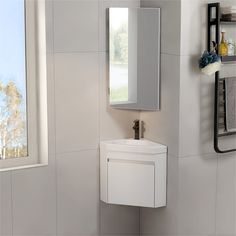 a bathroom with a sink, mirror and towel dispenser on the wall