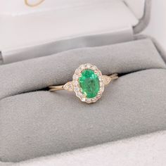 This beautiful dainty ring features a Zambian emerald in solid 14k yellow gold. A classic ring design perfect for daily wear, work or engagement. Elegant 14k Stamped Emerald Ring, Emerald Halo Ring In Yellow Gold, Yellow Gold Emerald Diamond Ring With Halo Design, Elegant 14k Gold Emerald Ring With Center Stone, Timeless Yellow Gold Emerald Promise Ring, Heirloom Style Emerald Ring With Halo, Heirloom Emerald Ring With Halo, Fine Jewelry 14k Gold Emerald Ring With Center Stone, 14k Gold Emerald Ring With Halo Design