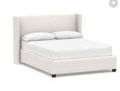 a bed with white linens and pillows on it's headboard, against a white background