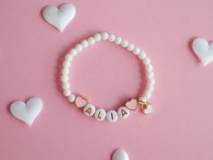 Kids Bracelet with Heart Charms and Natural White Stone Beads Adorn your child's wrist with our beautiful Kids Bracelet, featuring delicate colourful heart charms and natural white stone beads. This lovely accessory adds a touch of elegance and charm to any outfit, making it perfect for everyday wear or special occasions. Key Features: Heart Charms: Cute heart charms that symbolize love and friendship. Natural White Stone Beads: Elegant and durable, these beads add a touch of sophistication. The Heart-shaped Letter Beads Bracelet For Birthday, Cute Heart Bracelet With Letter Beads, Cute Heart Bracelet With Letter And Round Beads, Cute Heart-shaped Bracelets With Letter Beads, Adjustable Playful Heart Bracelet As Gift, Playful Heart-shaped Beaded Bracelets For Gift, Cute Heart-shaped Bracelet With Letter Beads, Playful White Bracelet With Charms, Heart-shaped Beaded Bracelets With Charms For Gift