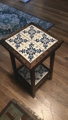 a coffee table with blue and white tiles on it in a living room next to a rug