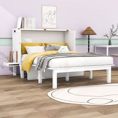 a white bed sitting on top of a wooden floor