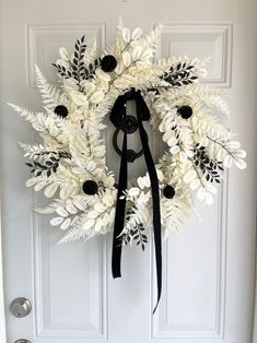 a wreath with black and white flowers on the front door