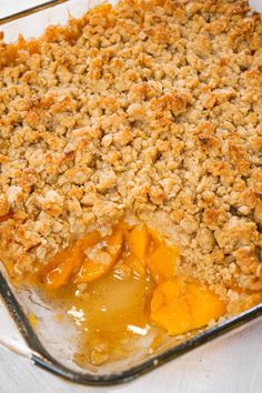 a casserole dish with peaches and crumbled topping