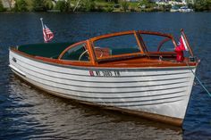 a small white boat in the water with an american flag on it's side