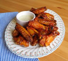 a plate full of chicken wings with dipping sauce