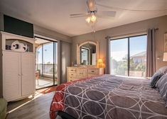 a bed room with a neatly made bed and sliding glass doors leading to an outside deck