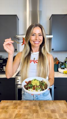 a woman holding a bowl of food in her hands