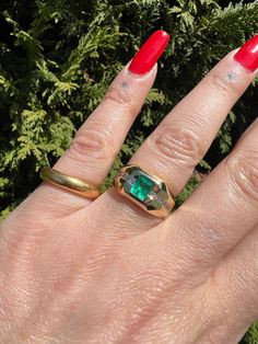 This gorgeous vintage ring features a 1 carat natural columbian emerald, flush set into 14k yellow gold. It is accented by two rows of approx .36 carats of VS2-G channel set diamonds, there are 6 on either side of the emerald. It is in great vintage condition showing light age and wear... expected with vintage jewelry. Ready to wear! and would make an amazing gift for anyone born in the month of May. Size US 7 1/8-7 1/4, and is sizable within reason by your jeweler Weighs approx 10 grams Emerald measures approx 4.97mm x 5mm Each diamond measures approx 2.1mm in diameter  ring width measures approx 10.15 and tapers down to 3.4mm setting measures approx 3.8mm high  Follow along on instagram @farewelltrading to keep up with my latest travel, finds, and first looks at new inventory. Each order Fine Jewelry Green Signet Ring With 17 Jewels, Timeless Yellow Gold Signet Ring With Emerald, Timeless Yellow Gold Emerald Signet Ring, Timeless Emerald Signet Ring For Anniversary, Green Diamond Signet Ring For Anniversary, Heirloom Green Diamond Ring Baguette Cut, Heirloom Green Diamond Ring With Baguette Cut, Emerald Cut Gemstone Signet Ring For Anniversary, 14k Gold Emerald Ring With Vs Clarity