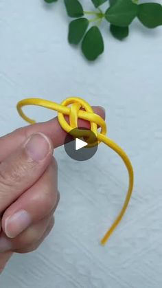 a person holding a yellow knot in their hand