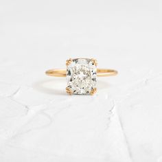 a cushion cut diamond ring in yellow gold