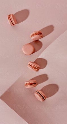 three pink macaroons sitting on top of a white table next to each other