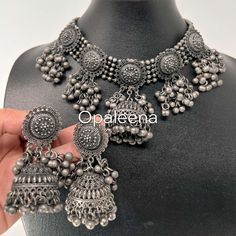 Stylish and exquisite ethnic - South-Asian - Indian - Punjabi - Pakistani - This bold yet stylish jewellery set has a gorgeous choker which ghungaroos at the bottom and medium to long size earrings in black finish at silver base. It's a push-back earring, and the choker string can be easily pulled depending on your neck circumference. Perfect gift for Mother's day.  The cool feature about this set is "the ghungaroo" itselfas you walk, it makes a little "ting" sound.   Black polish silver necklace choker set ghungaroo jewelry choker set Bollywood celebrity jewelry tribal boho necklace set matt finish choker Length (of necklace): 29.5 cms  Width (of necklace): 6.8 cms  Weight: 198 grams String length (the black string which is part of necklace): 32.5 cms Length (of earrings): 6.7 cms Width ( Metal Chandbali Jewelry Sets With Intricate Design, Festive Metal Choker With Intricate Design, Traditional Metal Choker With Oxidized Finish, Metal Choker With Oxidized Finish In Temple Jewelry Style, Oxidized Metal Temple Jewelry Choker, Bollywood Style Oxidized Metal Jewelry, Traditional Silver Chandbali Choker, Silver Metal Temple Jewelry Choker, Adjustable Bollywood Jewelry For Festivals