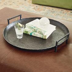 a tray that has some books on it and a drink in the glass next to it