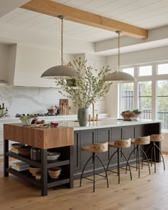 a large kitchen island with stools in front of it next to an open floor plan