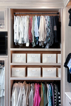 an organized closet with clothes and boxes on the bottom shelf, drawers below and white bins underneath