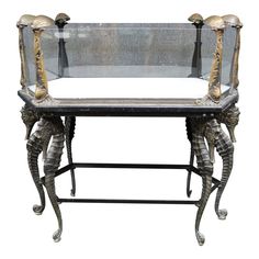 an ornate metal and glass table with legs