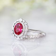 Beautiful Vintage Inspired Ruby Ring Made of Solid Sterling Silver, Rhodium Plated (925) Can be paired with one or two half-eternity Milgrain bands of your choice Accented with Simulated Diamonds (CZ) Center Stone: Ruby Grade: AAA Stone Cut: Oval Gem size: 7.0 x 5.0 mm Carat Weight: 0.76 (approx.) Gemstone creation: 100% Genuine Lab-Grown Ruby Stone Origin: Russia Handling time: 1-2 business days Free domestic shipping. Usually takes 2-5 business days. Wrapped & ready to give in a beautiful White Gold Ruby Ring With Halo For Wedding, Classic Ruby Ring With Halo Setting For Promise, Classic Halo Ruby Promise Ring, Classic Sterling Silver Halo Ring For Wedding, Anniversary White Gold Ruby Ring With Halo, Classic Halo Design Jewelry For Proposal, Classic Ruby Birthstone Ring With Halo Setting, Classic Diamond Ring With Halo Setting And Lab-created Ruby, Classic Rings With Lab-created Ruby For Gift