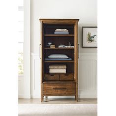 a wooden cabinet with drawers and towels on it's sides in a white room