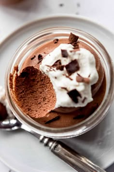 a dessert in a glass jar with whipped cream and chocolate shavings on top